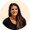 Smiling woman with long dark hair wearing a black top, on a white background.
